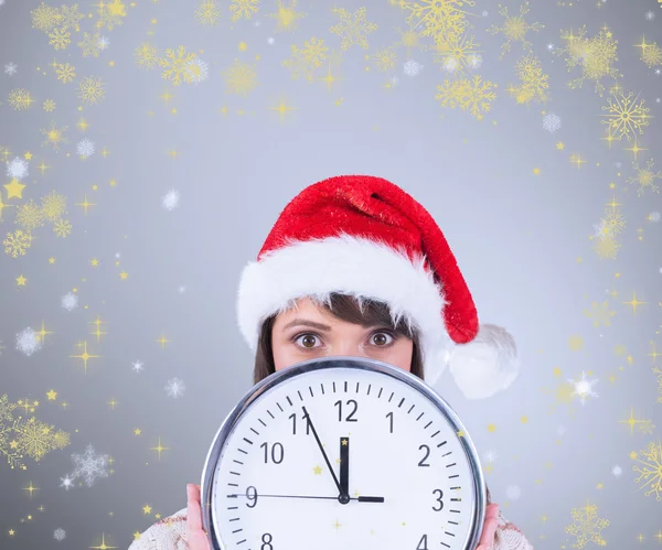 Festliche Brünette hält eine Uhr — Stockfoto