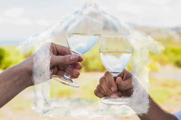 Composite image of couple clinking wine glasses outside — Stock Photo, Image
