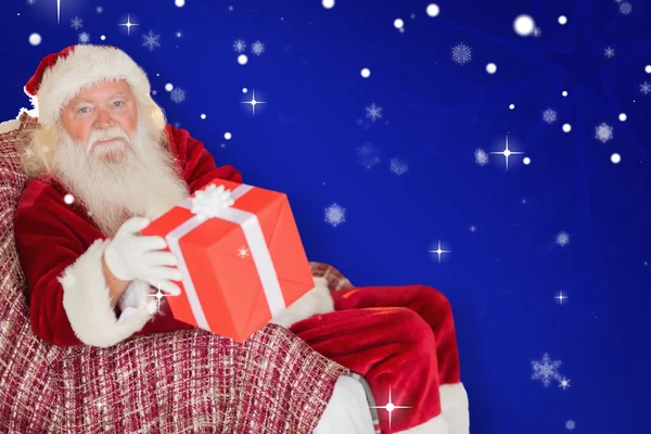 Санта-Клаус предлагает красный подарок — стоковое фото