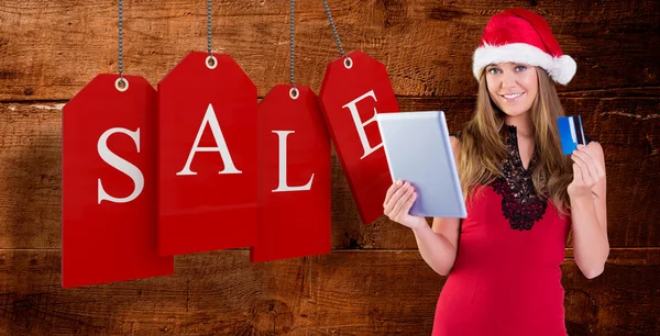 Festive blonde shopping online with tablet — Stock Photo, Image