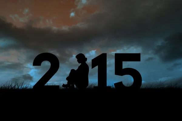 Woman sitting in 2015 sign — Stock Photo, Image