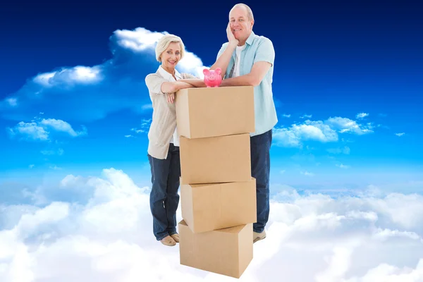 Älteres Paar lächelt mit Umzugskarton in die Kamera — Stockfoto