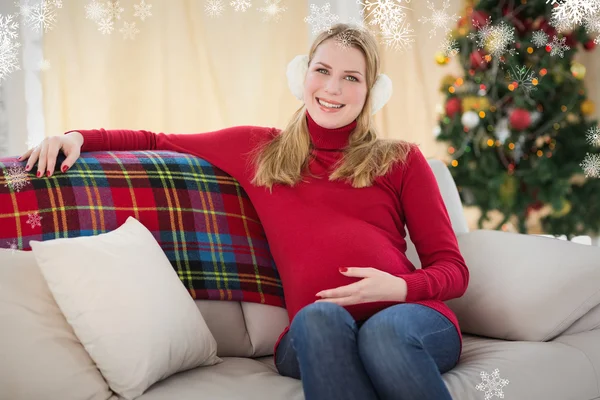 Beautiful pregnant woman sitting on a couch — Stock Photo, Image