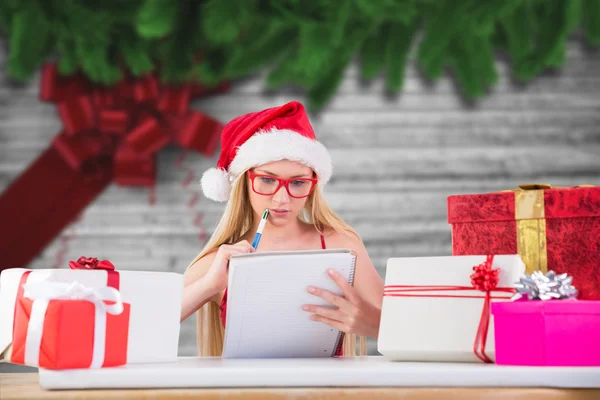 Zusammengesetztes Bild einer festlichen Blondine, die ihre Weihnachtsliste schreibt — Stockfoto