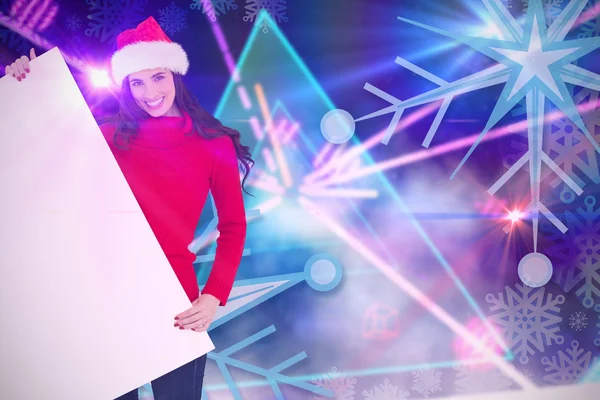 Brunette in santa hat showing poster — Stock Photo, Image