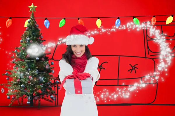 Morena festiva en sombrero de santa dando regalo — Foto de Stock