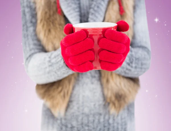 Vrouw in winter kleding bedrijf mok — Stockfoto