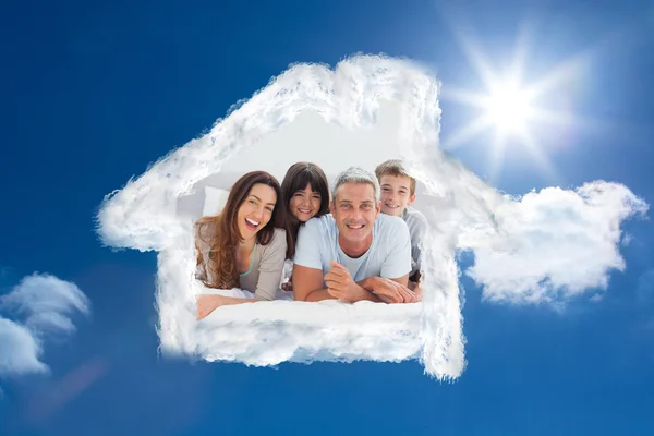 Composite image of happy family lying together — Stock Photo, Image