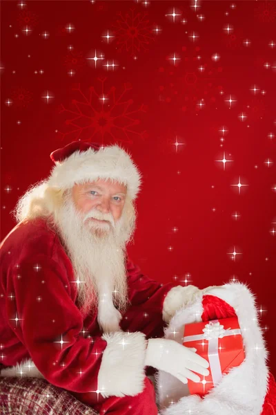 Father christmas taking red gift in bag — Stock Photo, Image