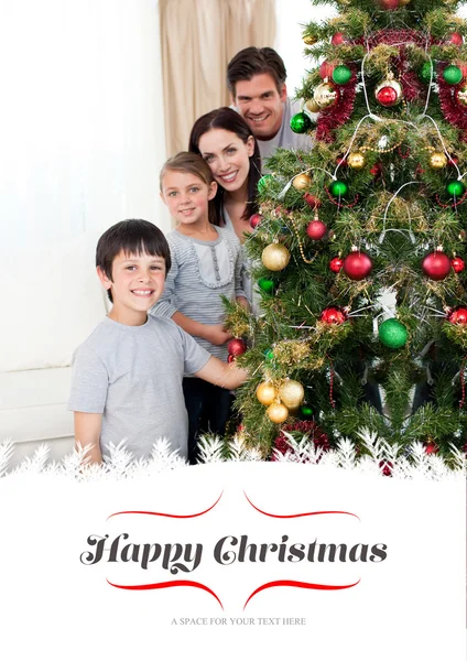 Zusammengesetztes Bild einer glücklichen Familie, die einen Weihnachtsbaum mit — Stockfoto