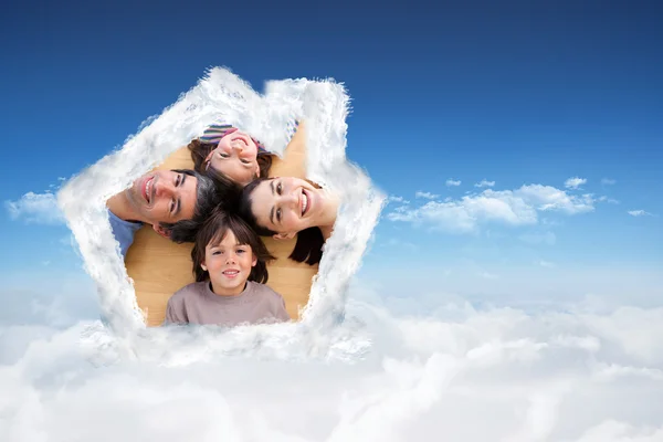 Smiling young family lying on the floor — Stock Photo, Image