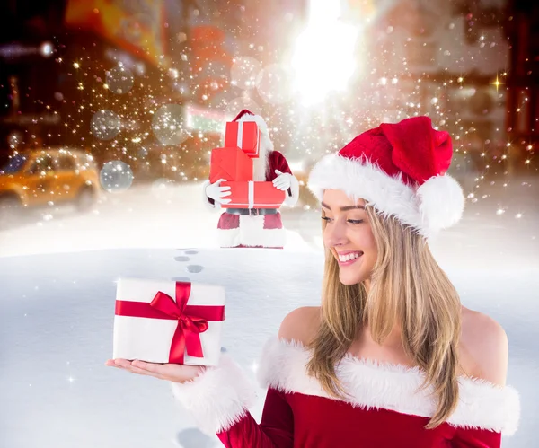 Pretty santa girl holding gift — Stock Photo, Image