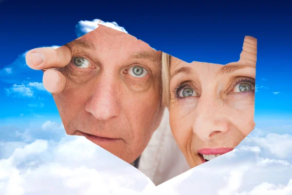 Older couple looking through rip — Stock Photo, Image