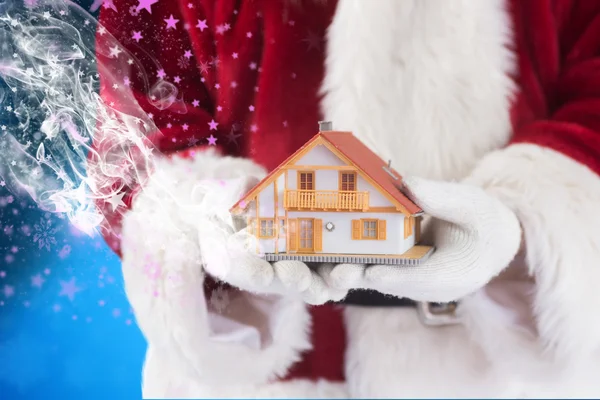 Санта держит крошечный дом — стоковое фото