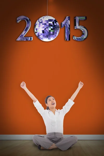 Cheering businesswoman sitting cross legged — Stock Photo, Image