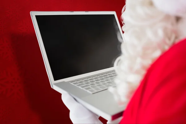 Composite image of father christmas using his laptop — Stock Photo, Image