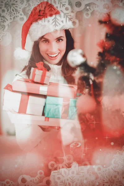 Festive brunette holding pile of gifts — Stock Photo, Image