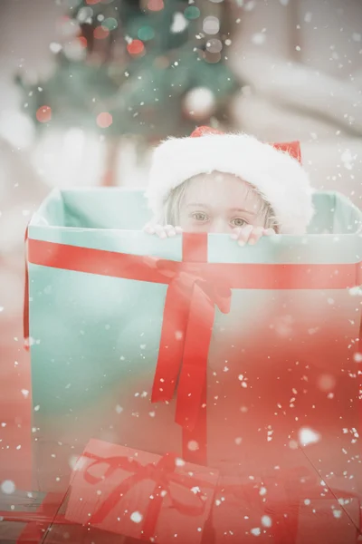 Niedliches kleines Mädchen sitzt in riesigen Weihnachtsgeschenk — Stockfoto