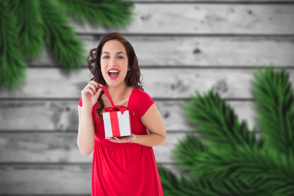Złożony obraz podekscytowany brunetka otwierając prezent na Boże Narodzenie — Zdjęcie stockowe