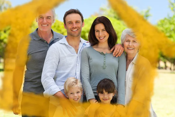 Composite image of family standing in the park — Stock Photo, Image