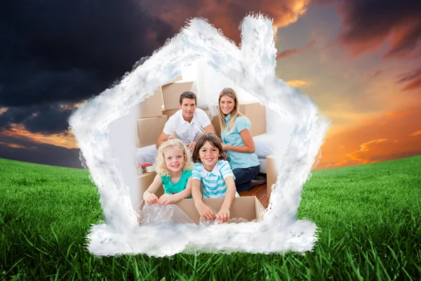 Composite image of smiling family packing boxes — Stock Photo, Image