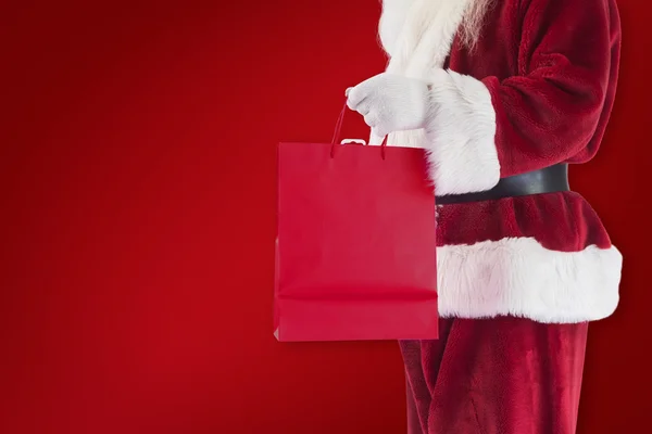 Santa draagt rode geschenk tas — Stockfoto