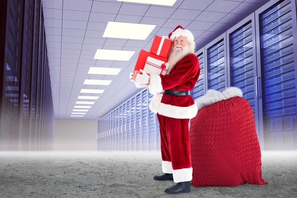 Santa claus carrying pile of gifts — Stock Photo, Image