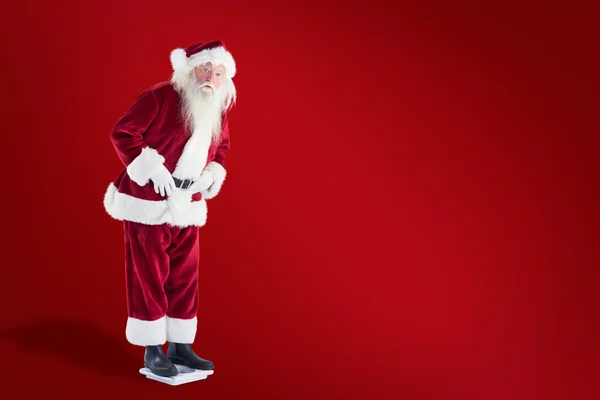 Santa is surprised about his weight — Stock Photo, Image