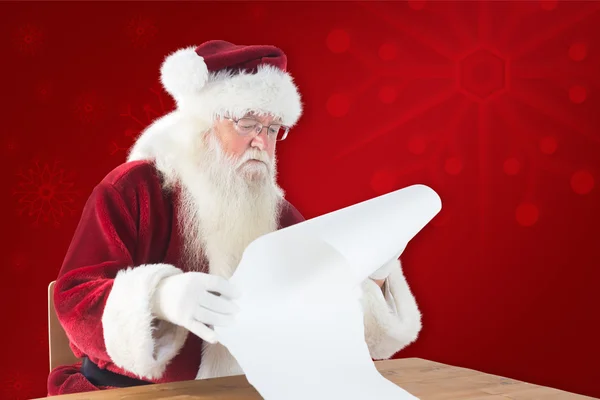 Santa czyta długą listę — Zdjęcie stockowe