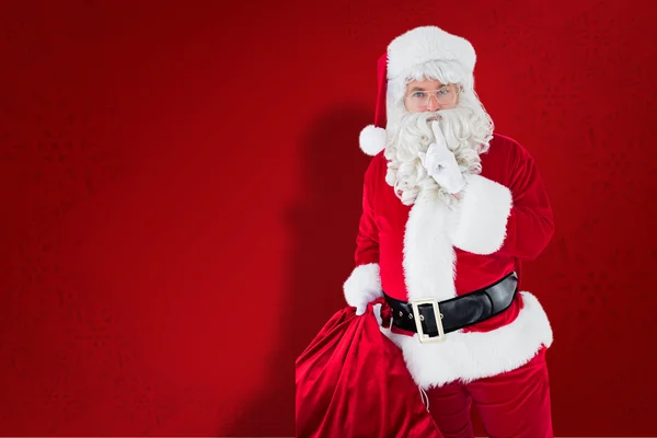 Immagine composita di Babbo Natale che tiene il suo sacco e mantiene un segreto — Foto Stock