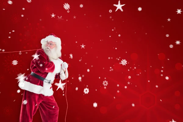Santa trekt iets met touw — Stockfoto