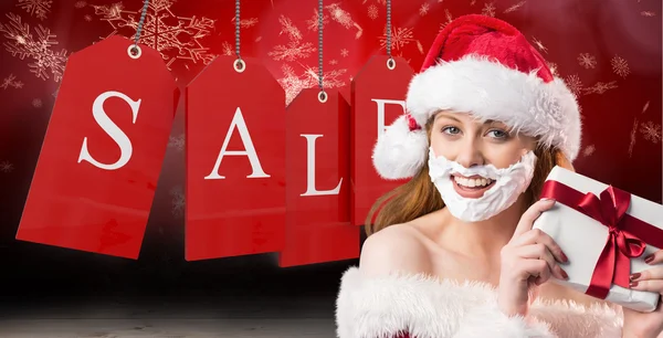 Festive redhead in foam beard holding gift — Stock Photo, Image