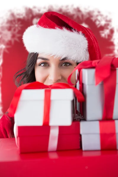 Composite image of festive brunette holding stack of gifts Royalty Free Stock Photos