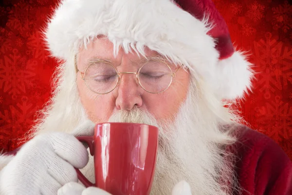 Санта пьет из красной чашки — стоковое фото
