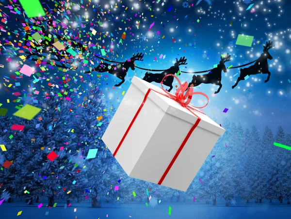 Santa flying behind big gift — Stock Photo, Image