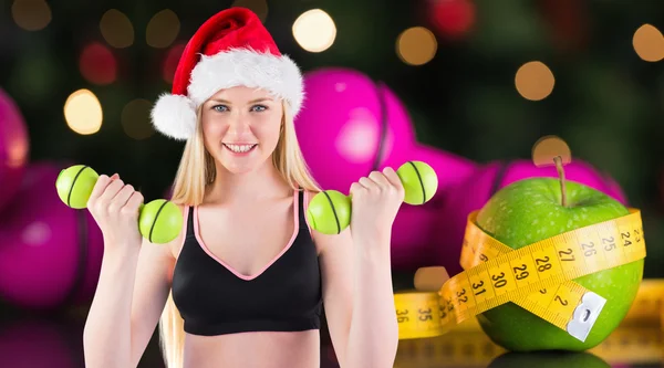 Imagen compuesta de la rubia en forma festiva sonriendo a la cámara — Foto de Stock