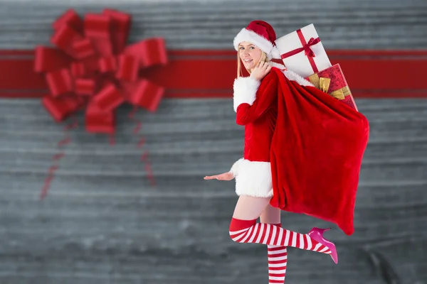 Festive blonde carrying sack of presents — Stock Photo, Image