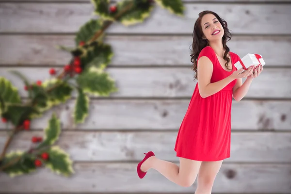 Комический образ стильной брюнетки в красном платье с подарком — стоковое фото