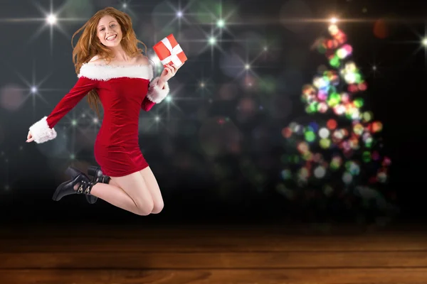 Festive redhead jumping with gift — Stock Photo, Image