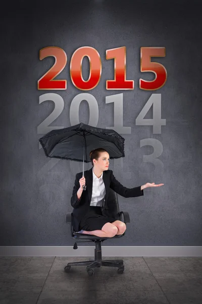 Composite image of businesswoman holding a black umbrella — Stock Photo, Image
