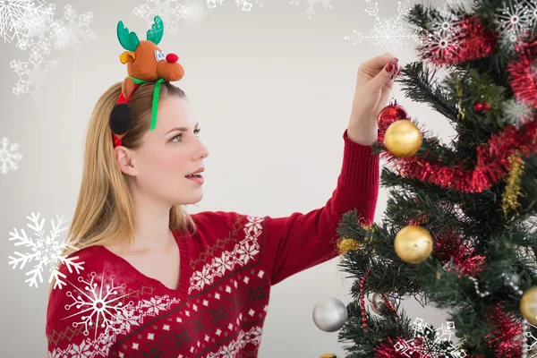 Woman hanging christmas decorations on tree — Stock Photo, Image