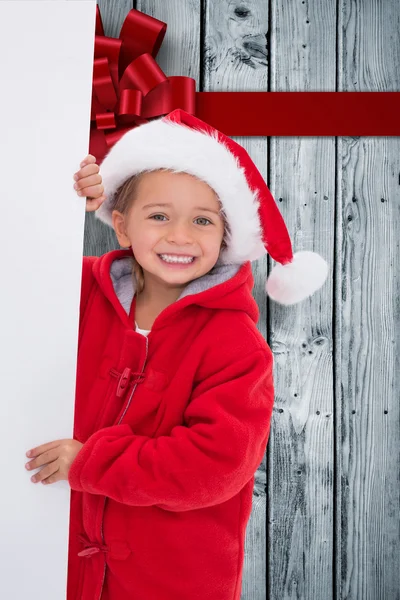 Composite image of festive little girl holding poster — Stock Photo, Image