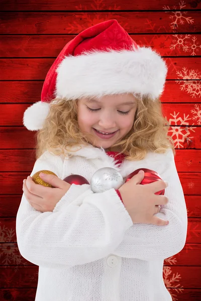 Imagen compuesta de una niña festiva sosteniendo chucherías —  Fotos de Stock