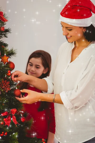 Moeder en dochter opknoping kerstversiering op boom — Stockfoto