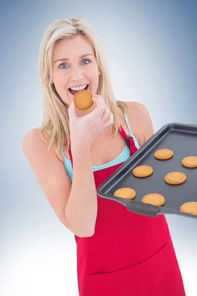 Glückliche Blondine isst heiße Plätzchen — Stockfoto