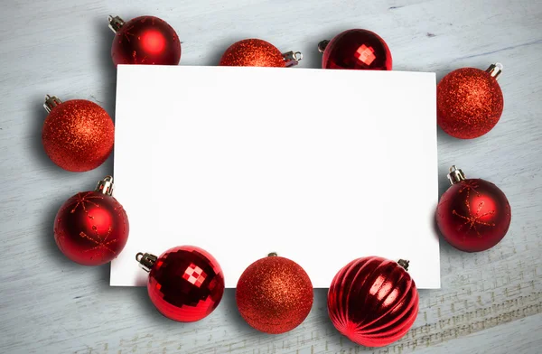 Sammansatt bild av röda julgranskulor kring vit sida — Stockfoto
