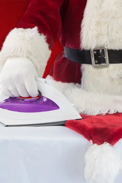 Father Christmas is ironing his hat — Stock Photo, Image