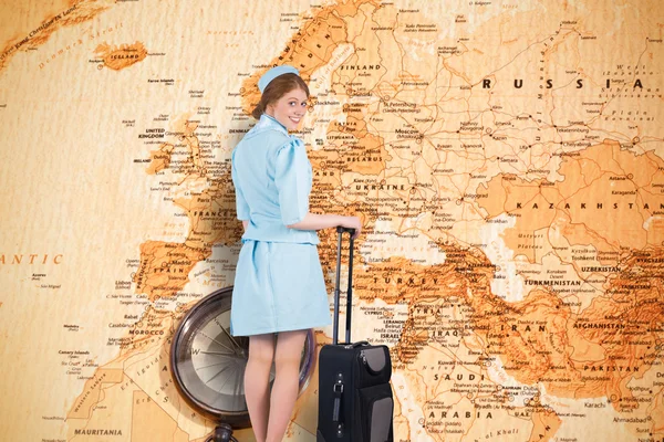 Pretty air hostess leaning on suitcase — Stock Photo, Image