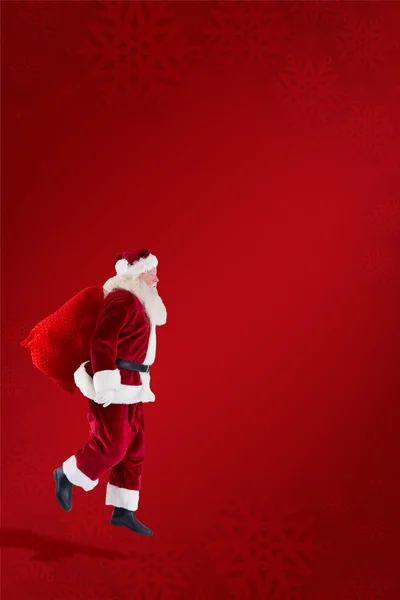 Santa claus carrying sack — Stock Photo, Image