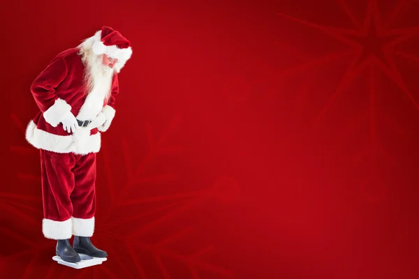 Santa looks down to personal scales — Stock Photo, Image